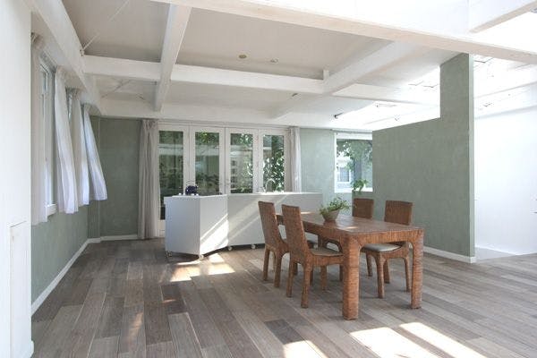 古材風のフローリングに可動式オープンキッチンが設置された素朴な空間