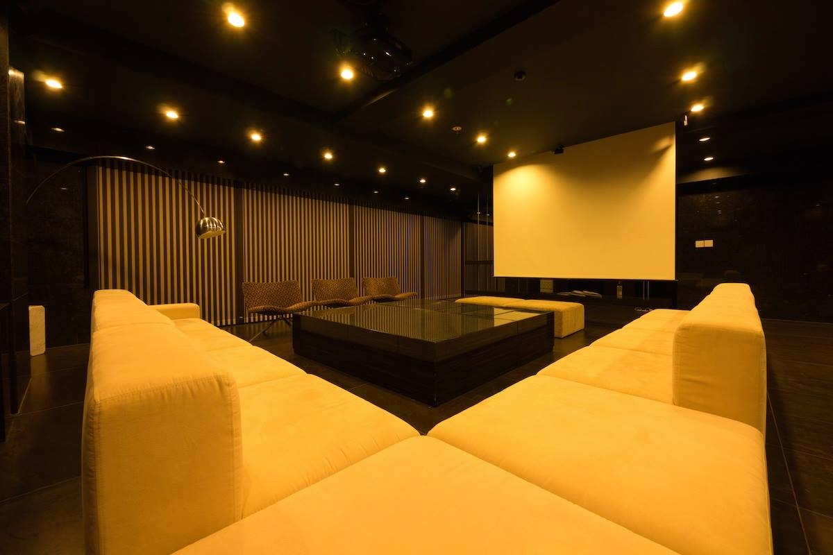 レイアウト自由なソファースペース。100インチプロジェクターとシアターシステム完備。