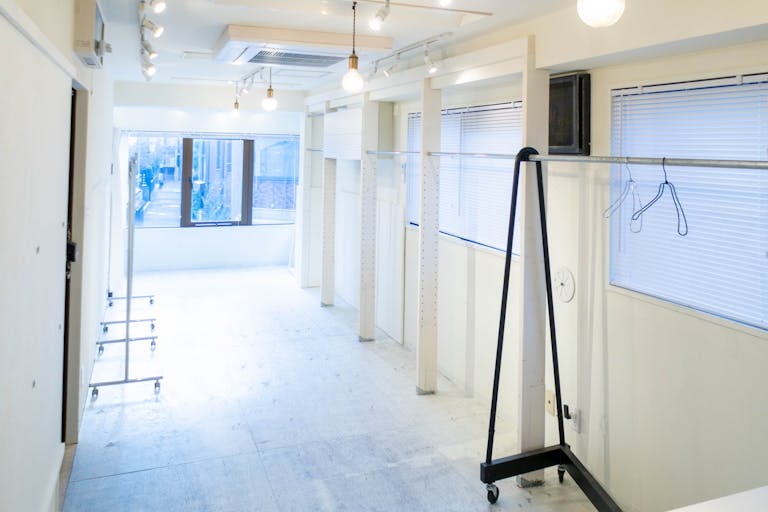 白を基調としたシンプルなショールーム空間。 可動式ラックとライティングを備え、展示会・受注会・撮影・商談など、用途に応じて柔軟にレイアウト可能です。